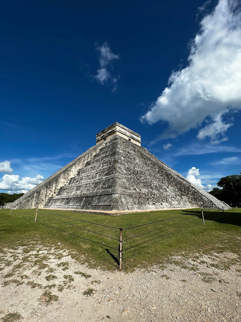 a large pyramid sitting on top of a lush green field