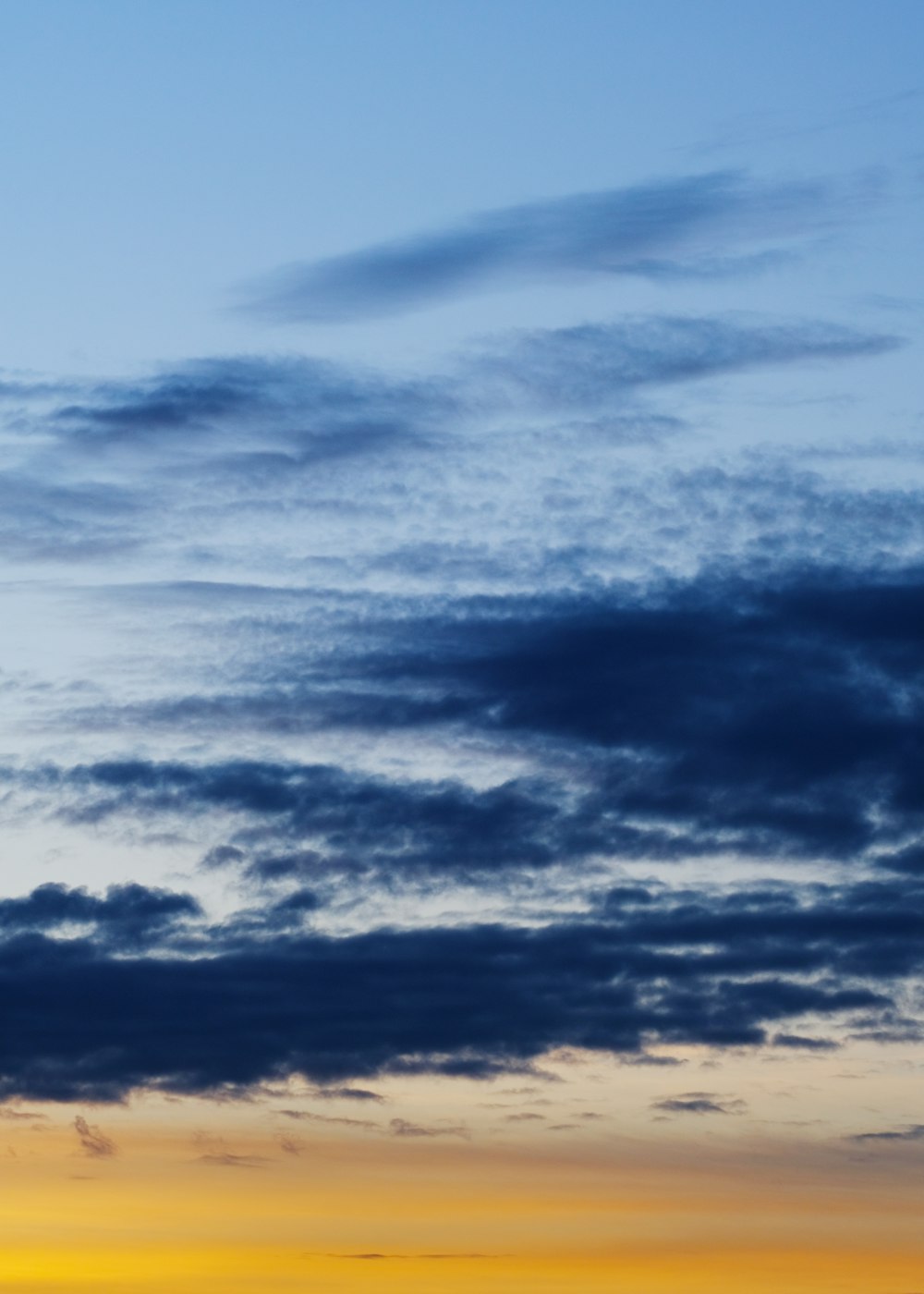 a plane flying in the sky at sunset