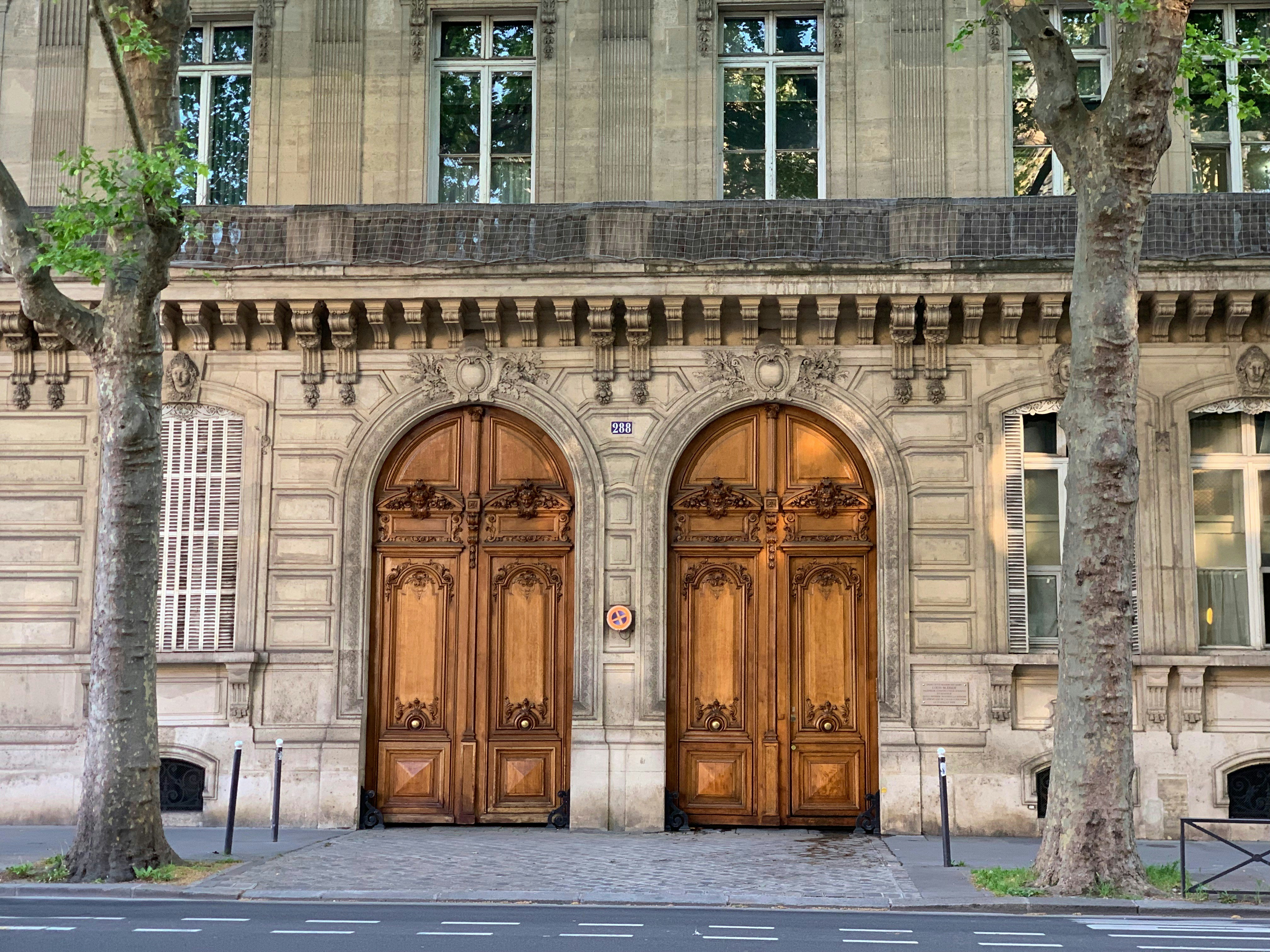a couple of large wooden doors in front of a building, 