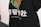 A close-up of a garment, such as a shirt or hoodie, adorned with a colorful graphic consisting of orange, green, and black colors. Below the graphic, there is text in white, which includes both large Chinese characters and smaller English text that reads 'TeenTeam Canton Local'.
