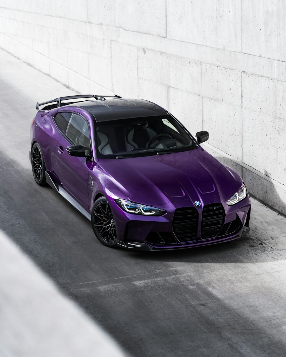 a purple sports car driving down a road