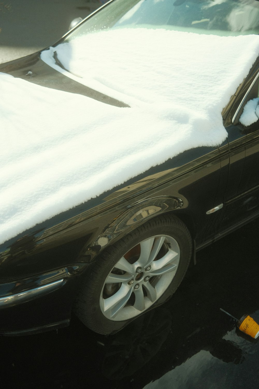 a car covered in snow sitting in a parking lot