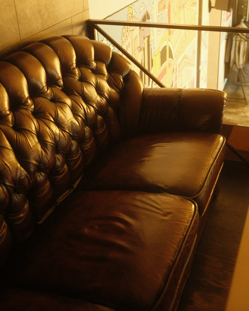 a brown leather couch sitting on top of a wooden floor