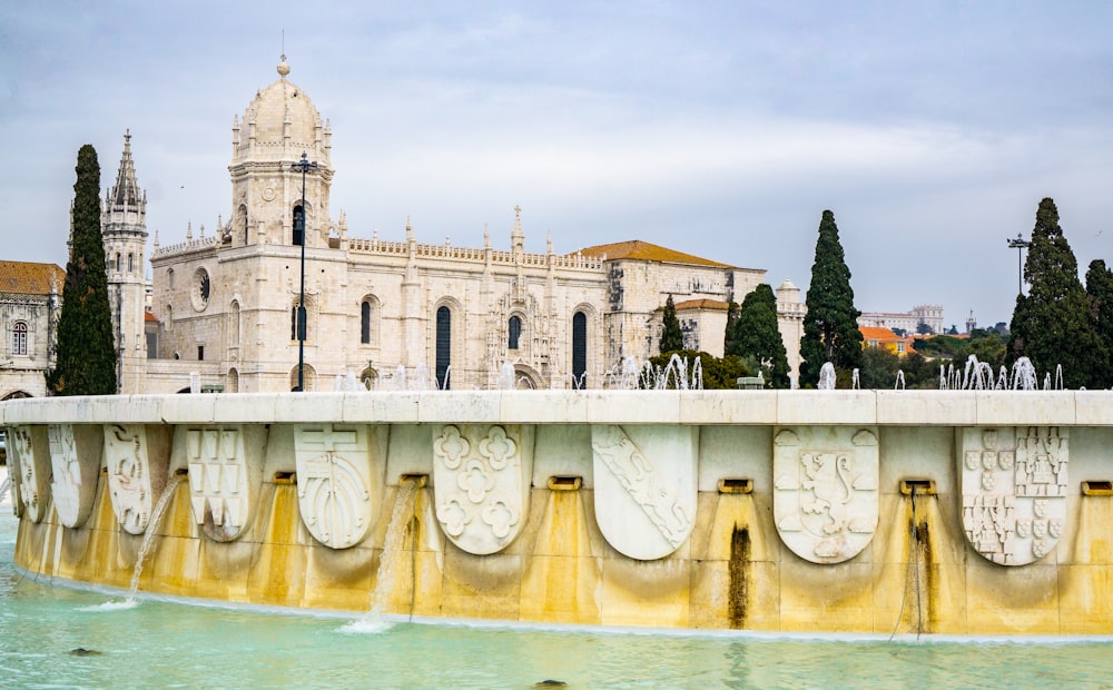 a fountain in front of a building with a clock tower in the background