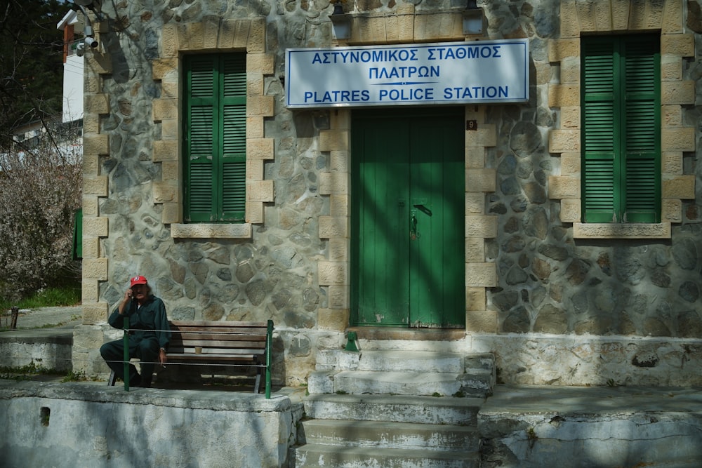 Un homme assis sur un banc devant un immeuble