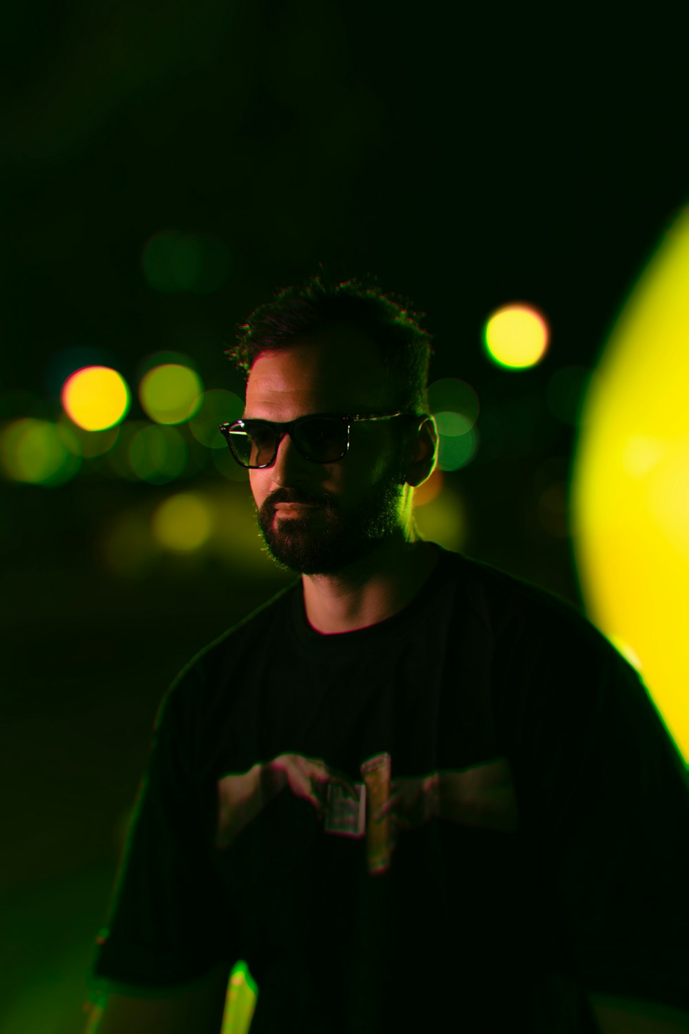 a man wearing sunglasses standing in the dark