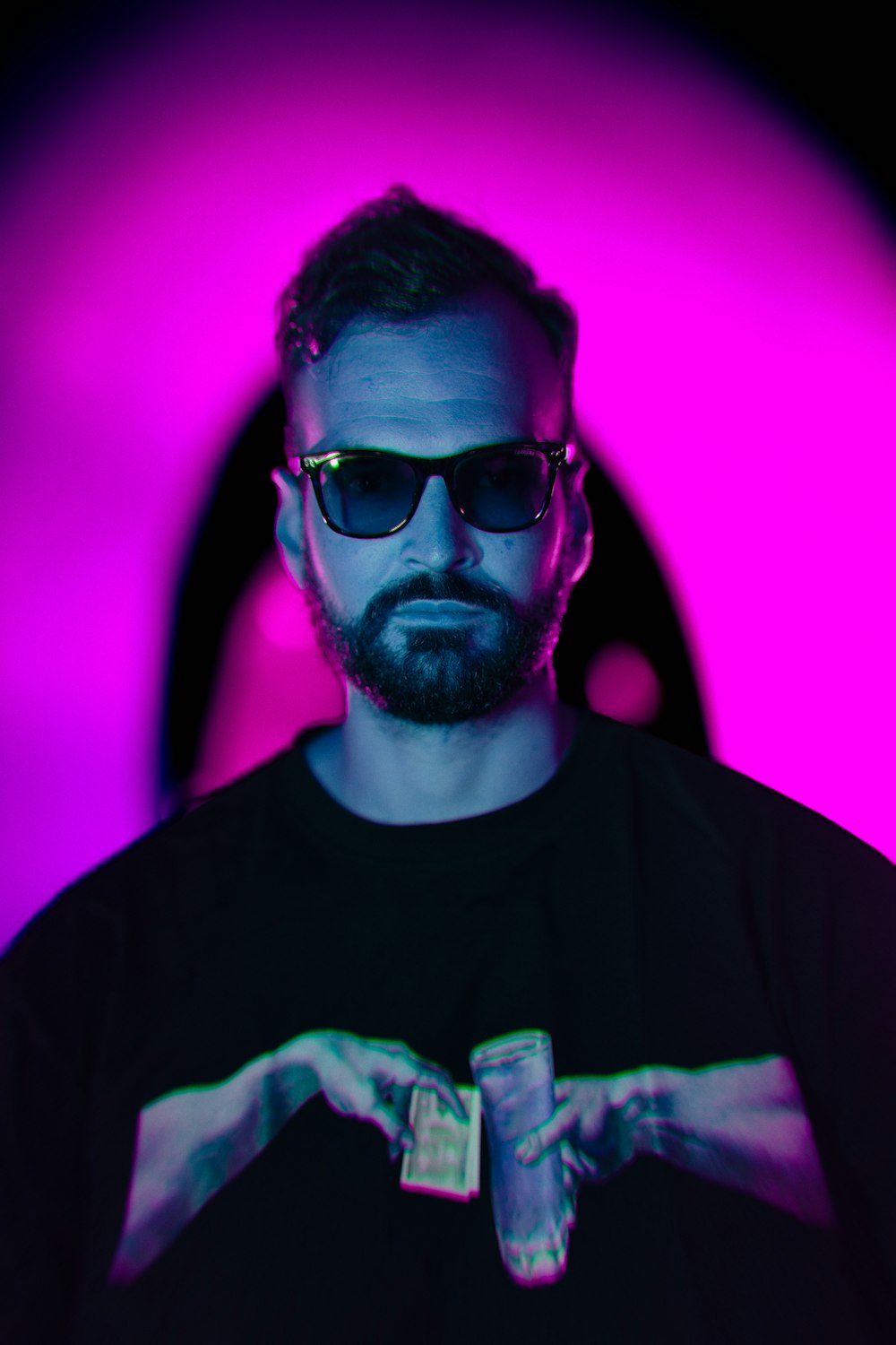 a man with a beard wearing sunglasses and a black t - shirt