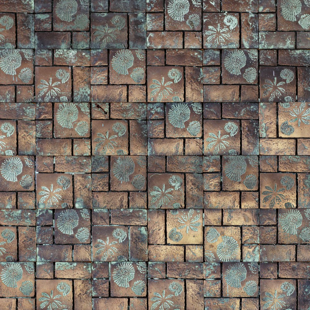 un mur de briques avec un motif de fleurs dessus