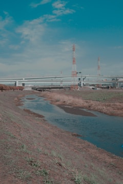 Engineers consulting over blueprints beside a flowing stream.