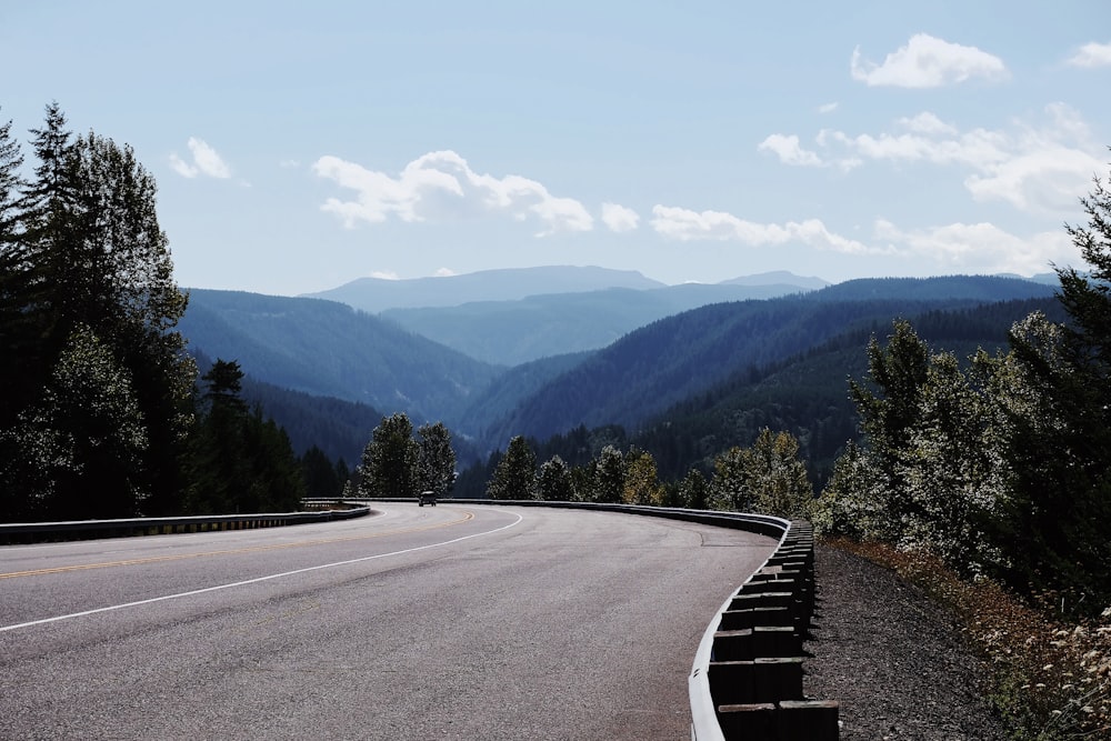 a curved road with mountains in the background