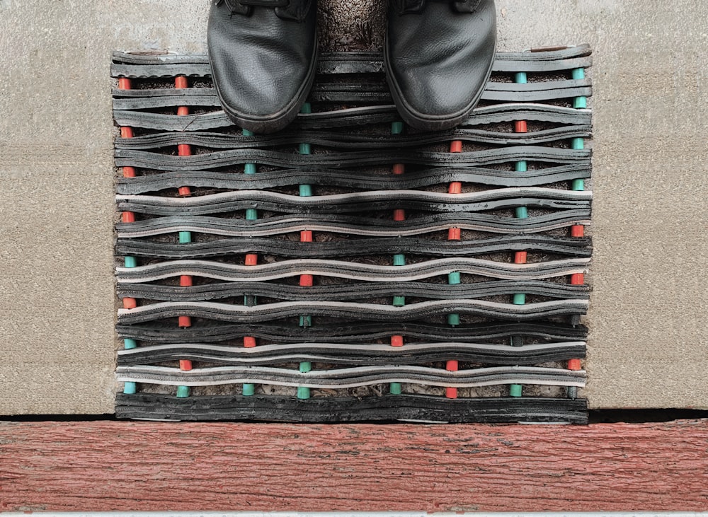 une paire de chaussures noires assises sur une pile de chaussures
