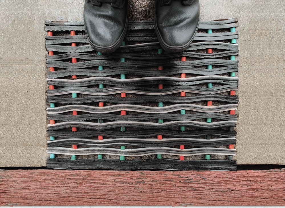 a pair of black shoes sitting on top of a pile of shoes