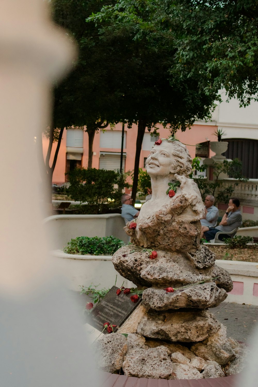 a group of people sitting around a statue