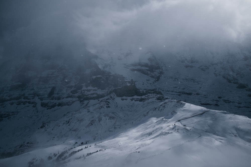 a mountain covered in snow under a cloudy sky