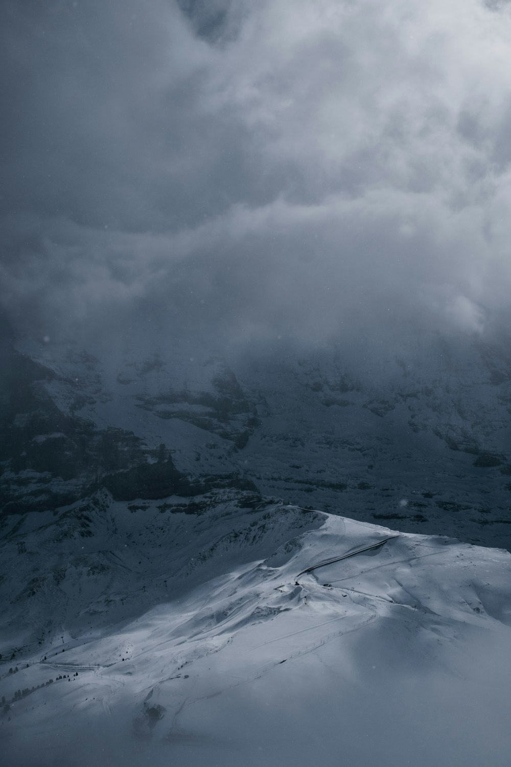 a mountain covered in snow under a cloudy sky