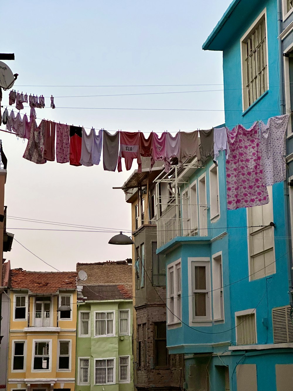 uma fileira de casas coloridas com roupa pendurada em uma linha