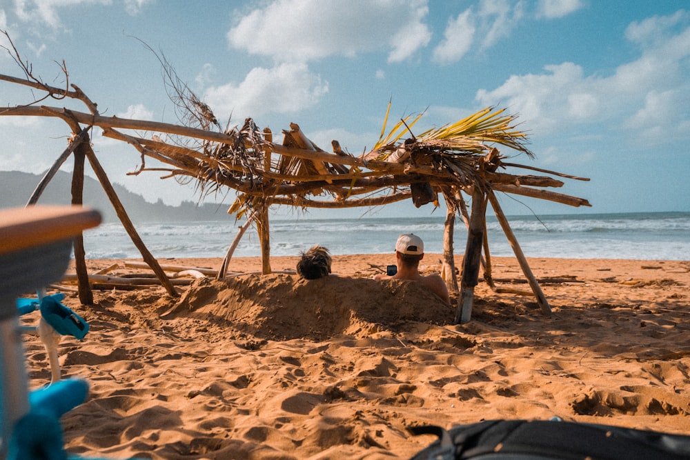 a group of people sitting on top of a sandy beach