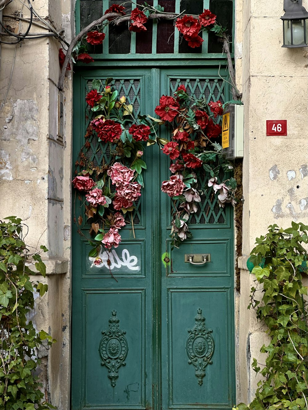 a green door with a bunch of flowers on it