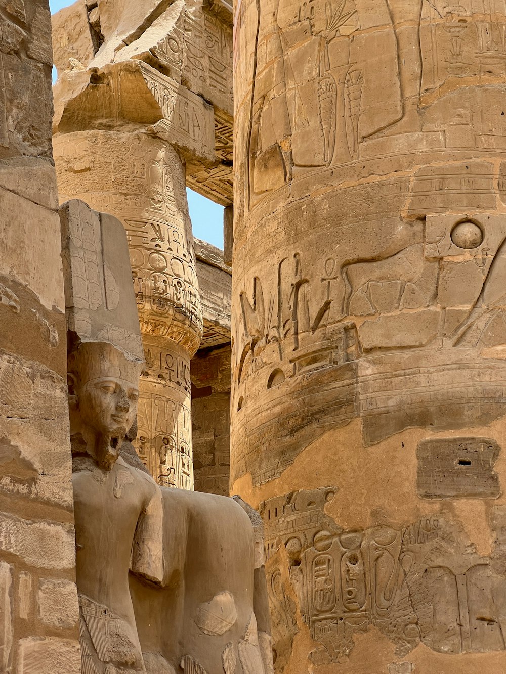 a statue of an egyptian god next to a pillar