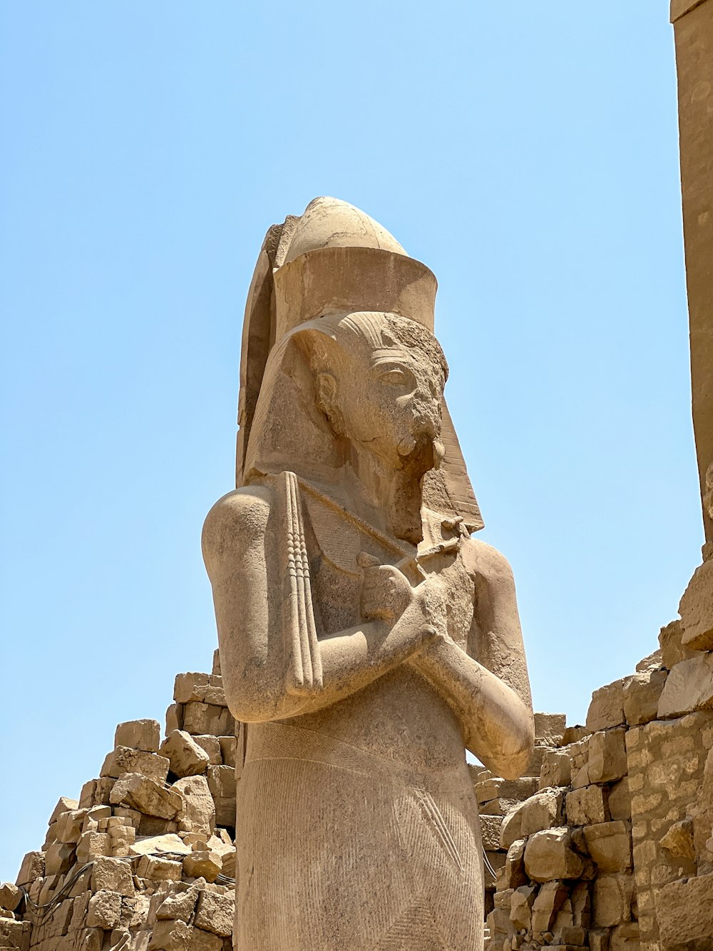 Una estatua de un dios egipcio sosteniendo un arpa