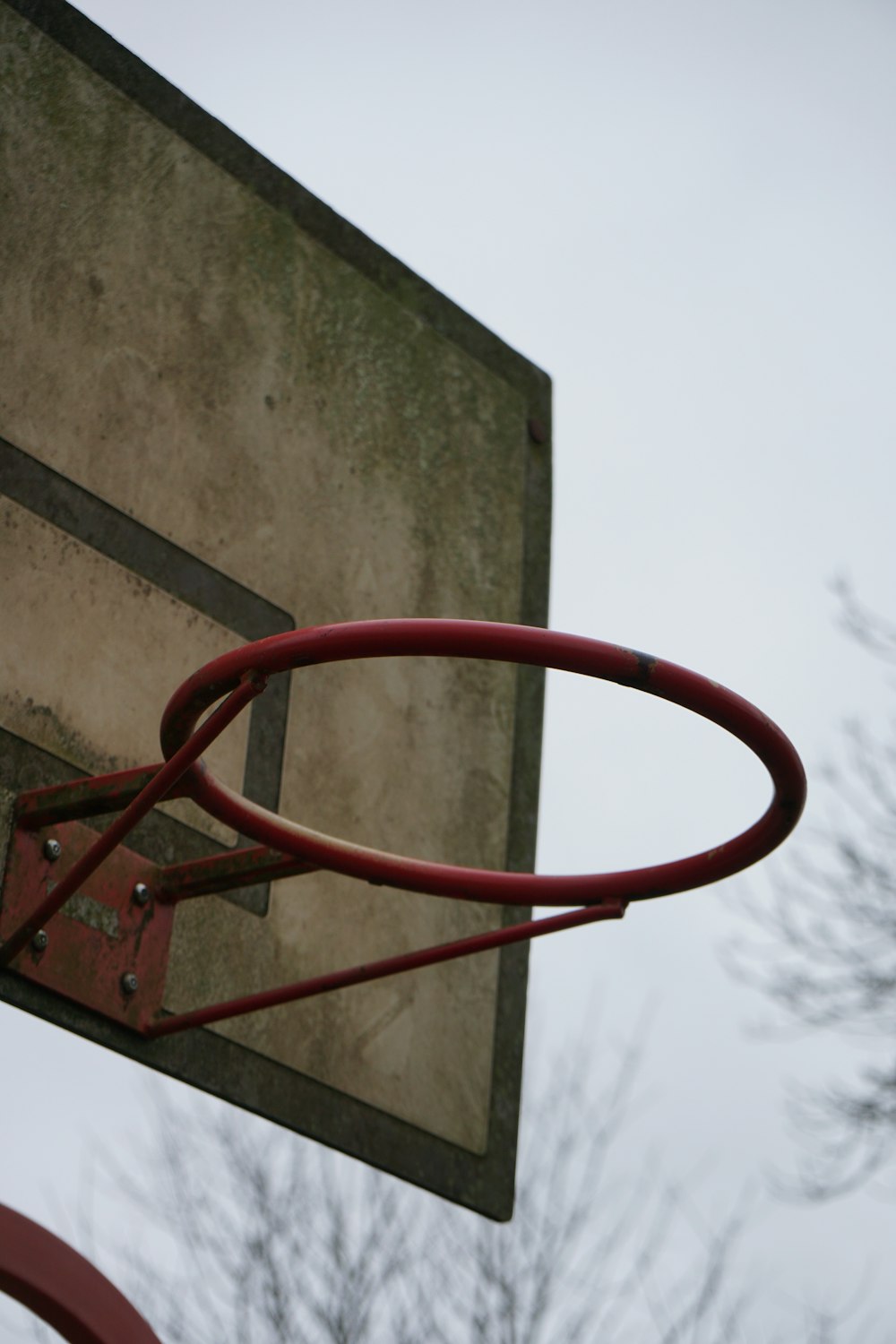 a close up of a basketball hoop with trees in the background