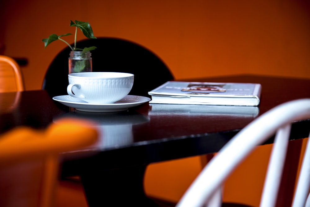 a table with a cup and saucer and a book on it