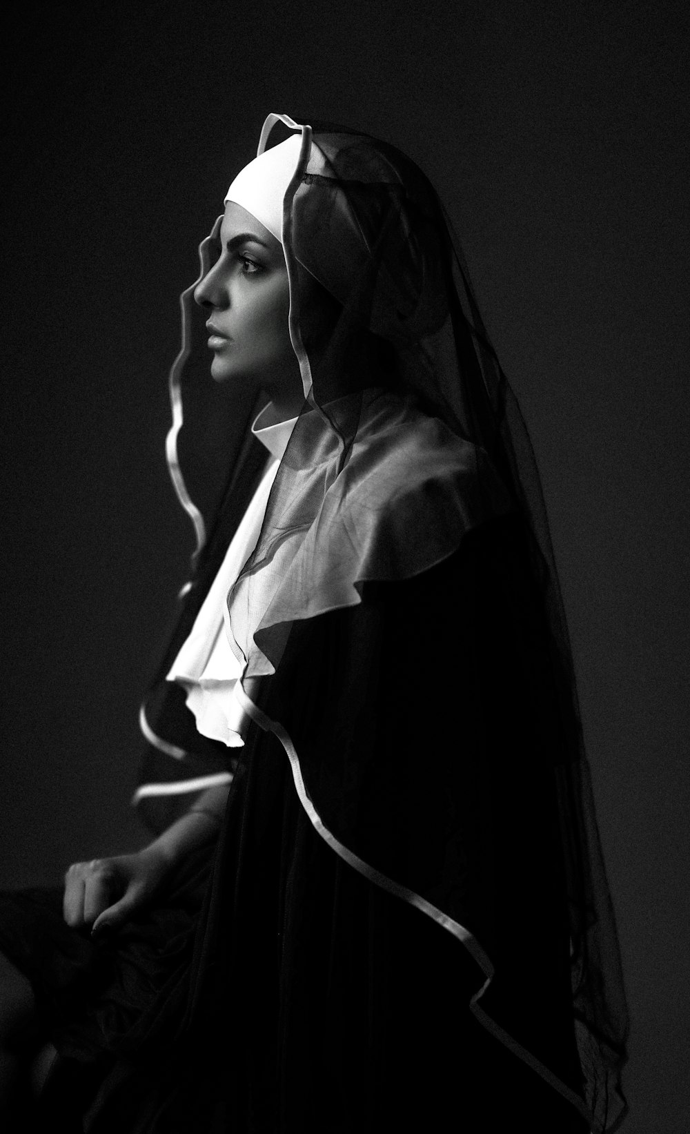 a black and white photo of a woman wearing a veil