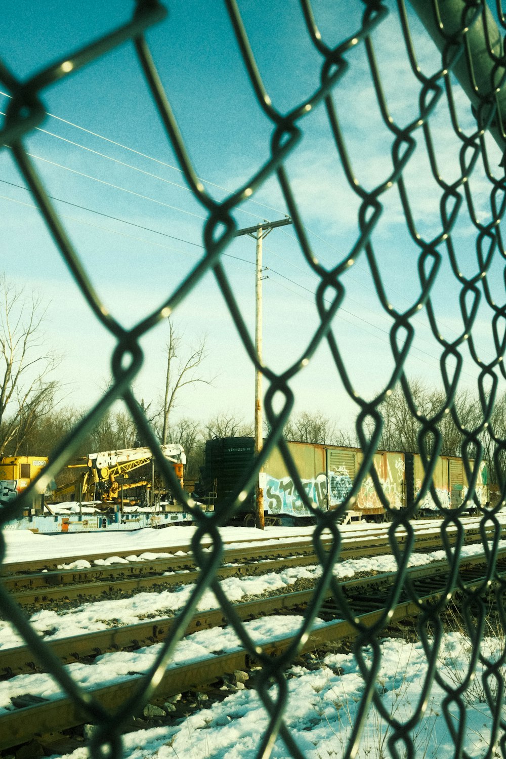 a view of a train track through a chain link fence