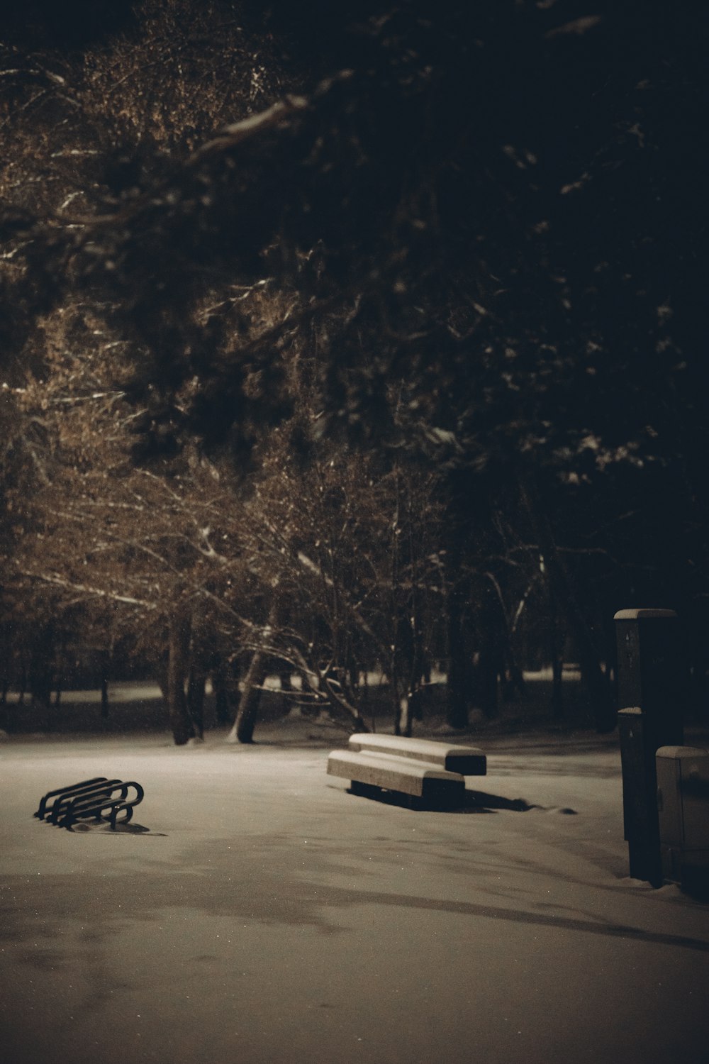 a park bench sitting in the middle of a snow covered park
