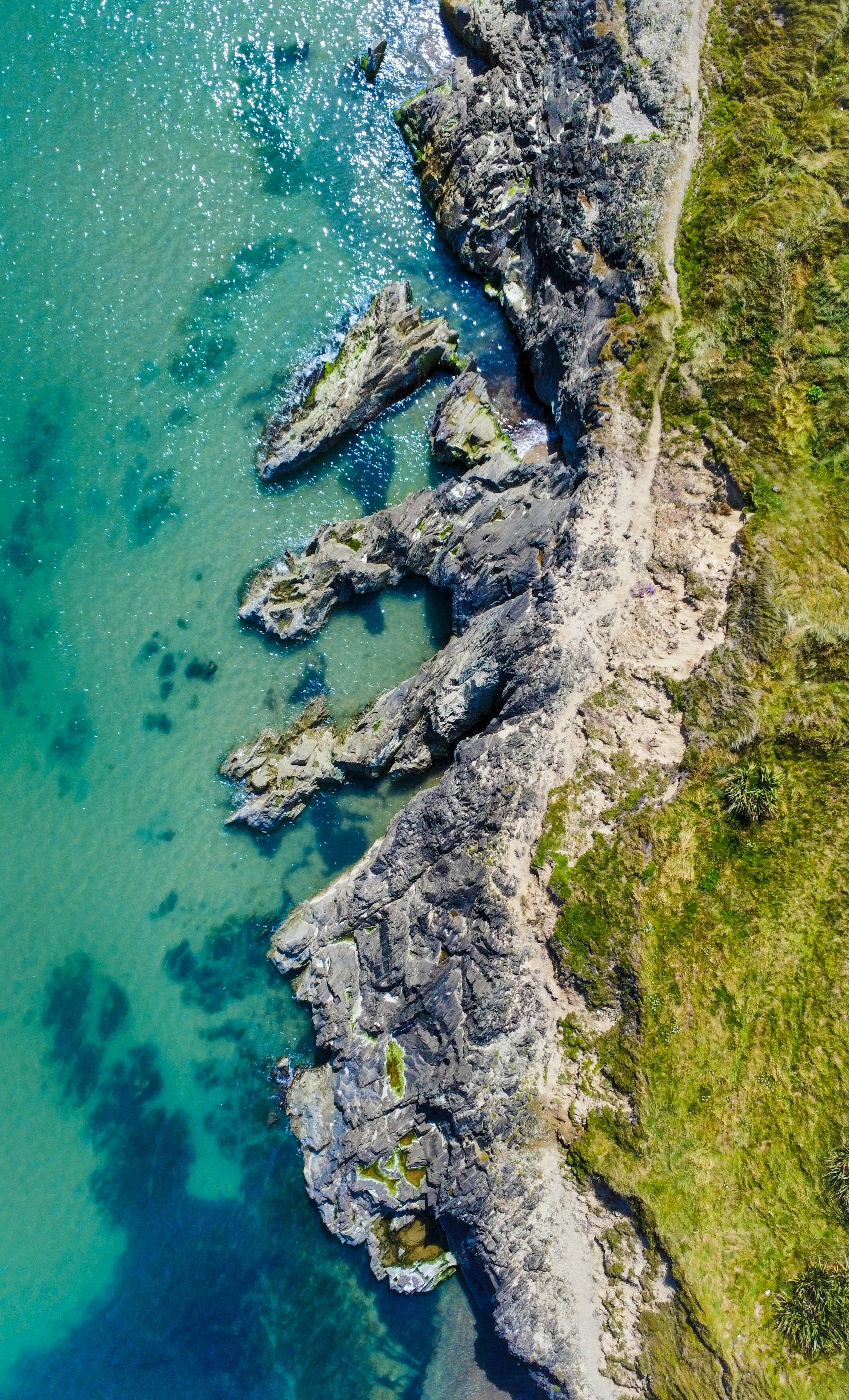 une vue aérienne d’une côte rocheuse aux eaux bleues