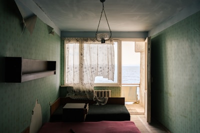 Bright bedroom with nautical-themed decor and airy curtains.