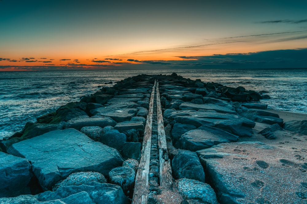 a long line of rocks sitting on top of a body of water