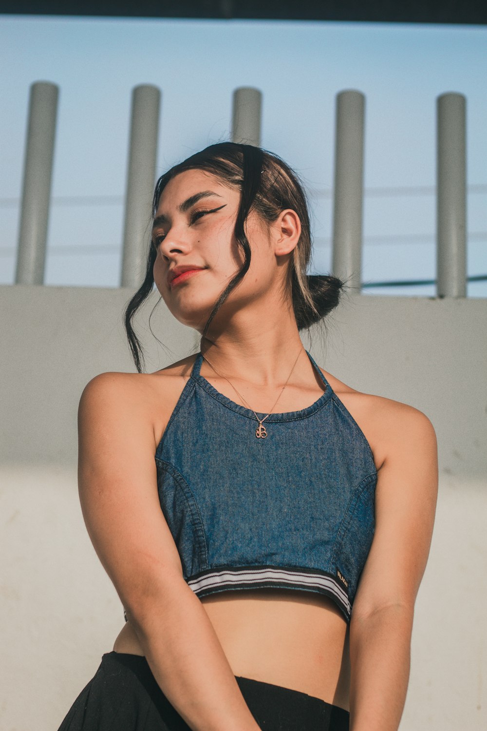 a woman wearing a denim top and black pants