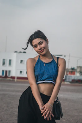 A model wearing a casual navy blue shirt paired with khaki pants in an urban setting.