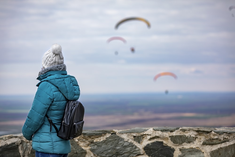 a woman standing on top of a stone wall