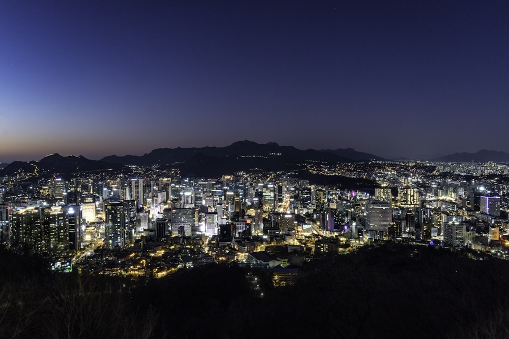 a view of a city at night from the top of a hill