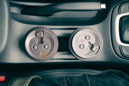 A portable USB bottle warmer placed in a car cup holder, ready for use.
