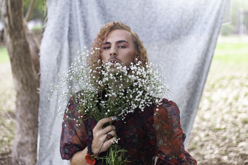 a woman holding a bunch of flowers in front of her face