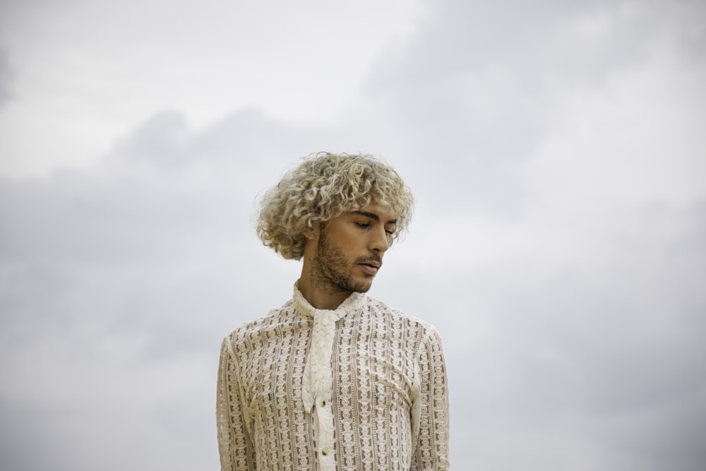 a man with curly hair wearing a white shirt