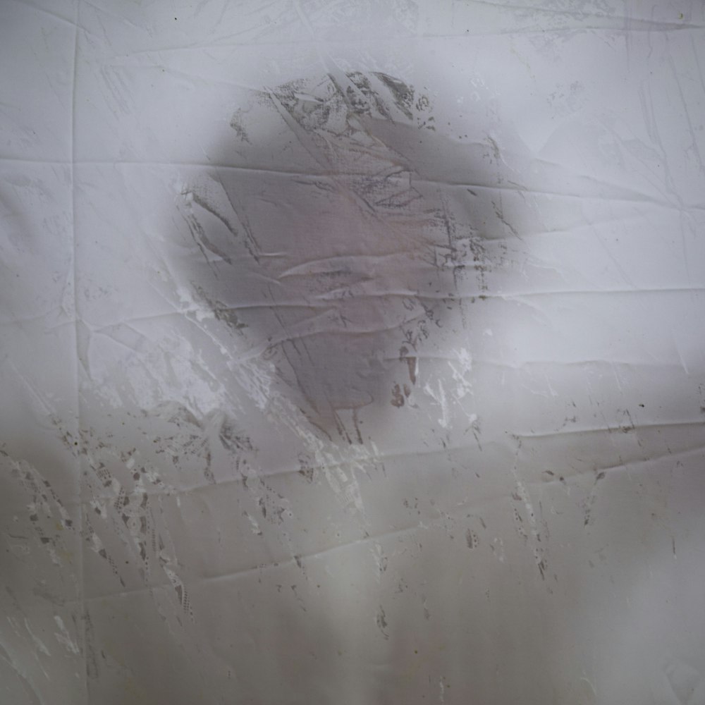 a man's face is shown through a hole in a sheet of paper