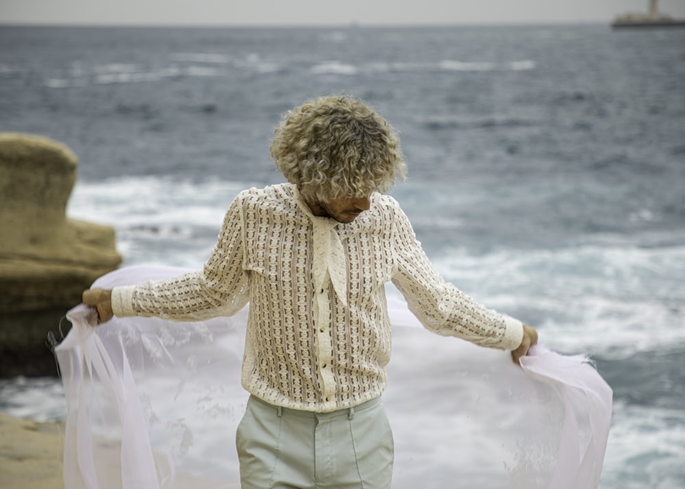 a man standing on a beach next to the ocean