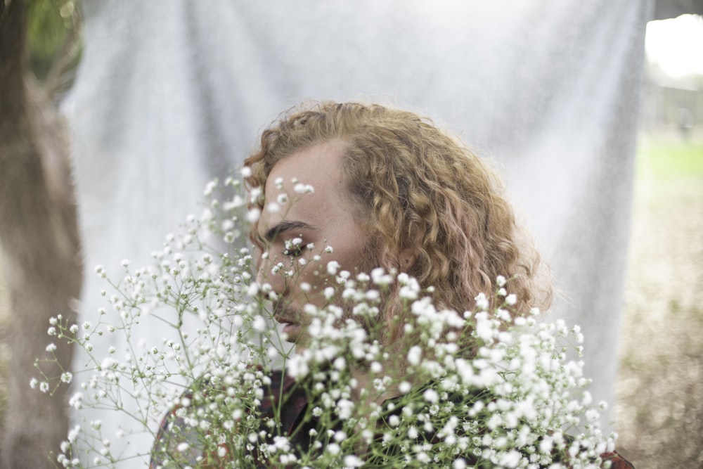 a woman holding a bouquet of white flowers