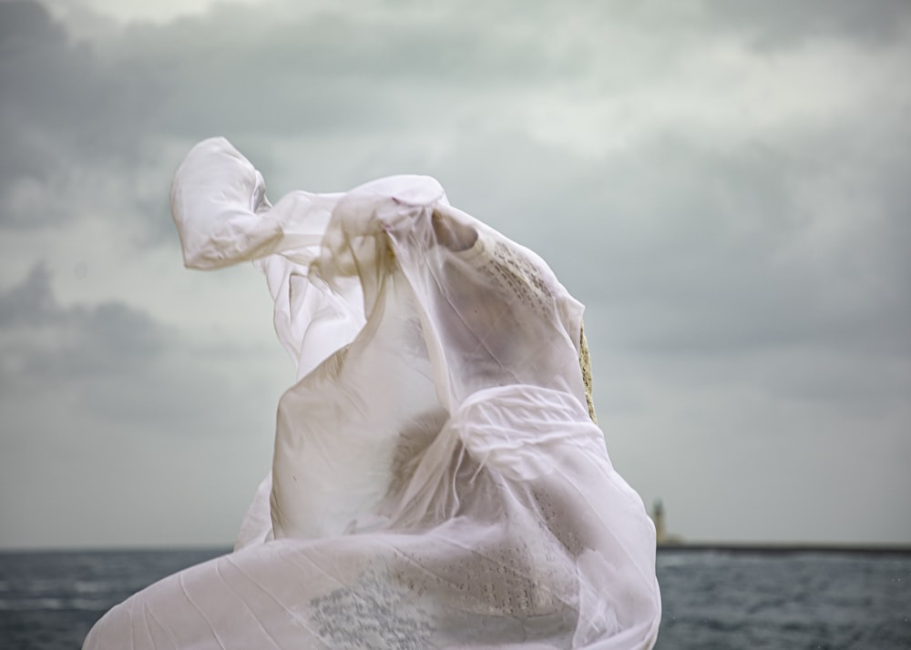 a woman in a white dress standing on a beach