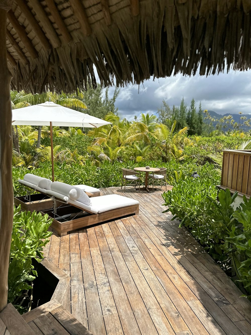 a wooden deck with lounge chairs and umbrellas