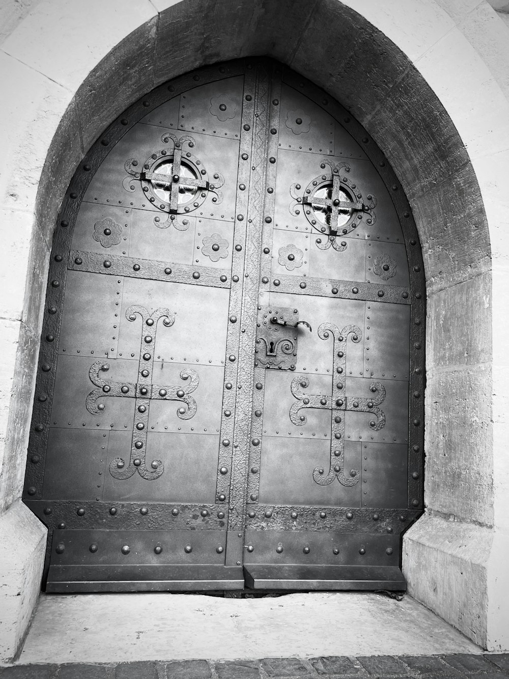 a black and white photo of a large metal door