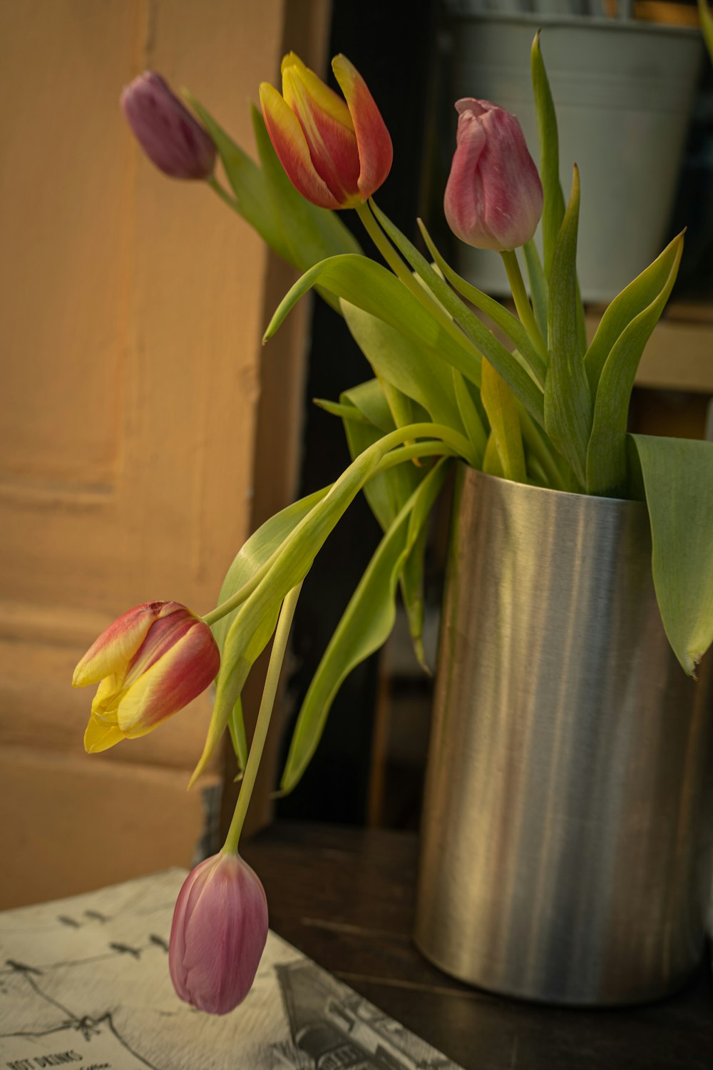 a bunch of tulips in a vase on a table