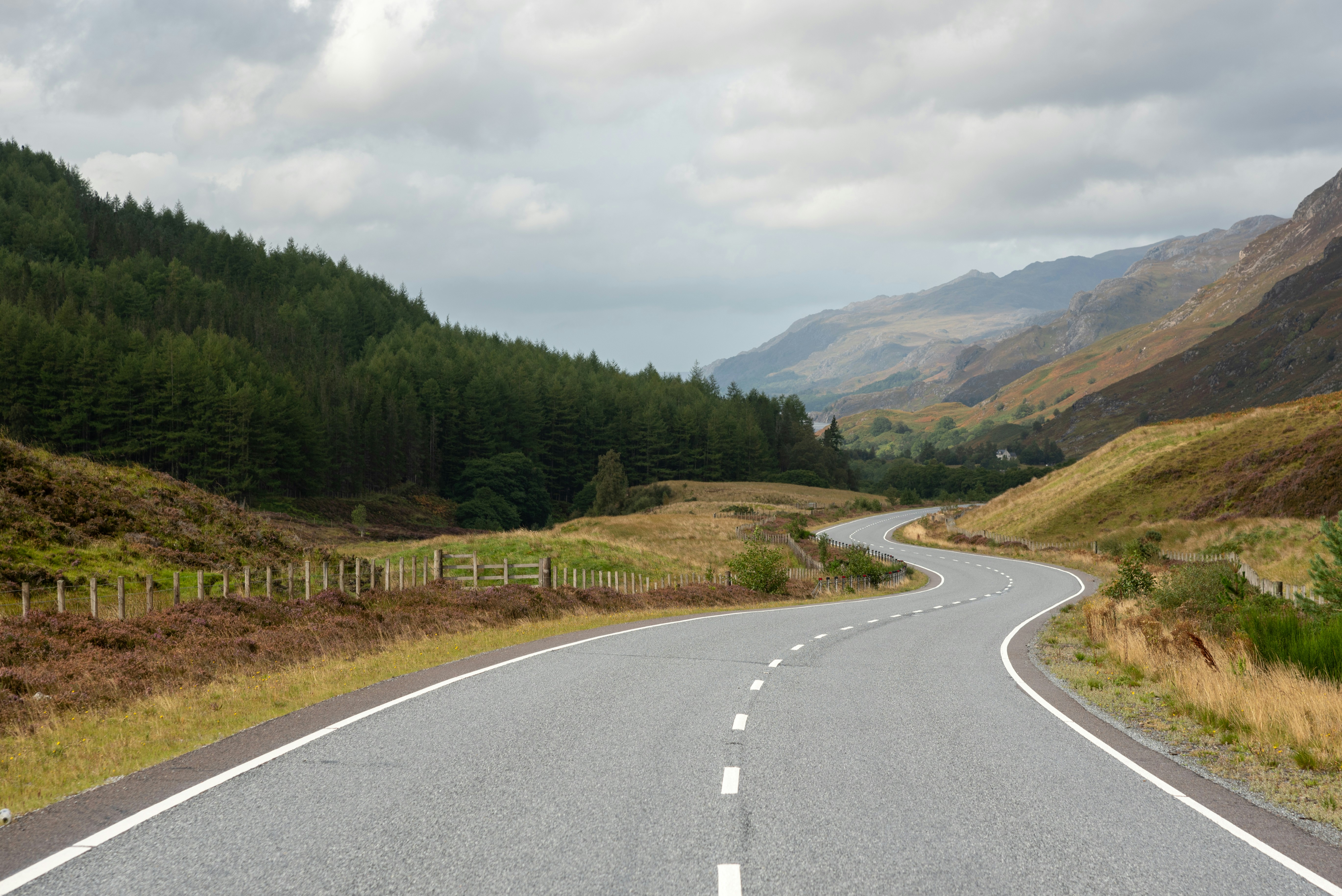 an empty road in the middle of a mountain range