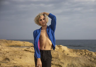 A candid shot of a model posing naturally outdoors with the volcanic landscape of Lanzarote in the background.
