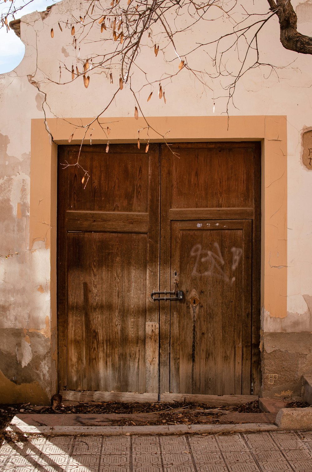 a wooden door with graffiti on the side of a building