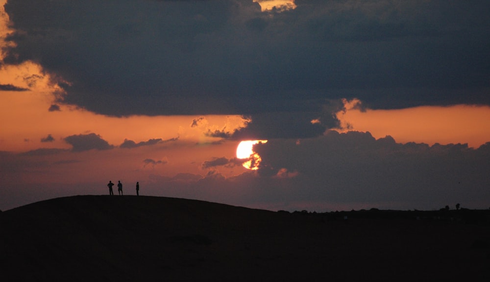 a couple of people standing on top of a hill